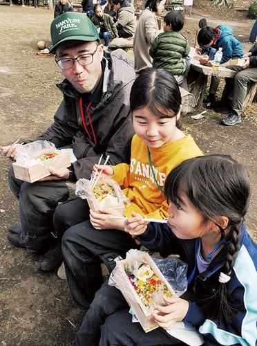 弁当をほおばる親子