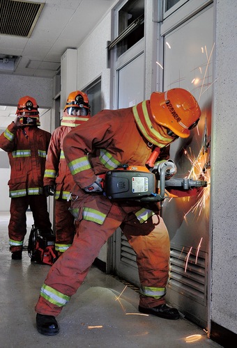 「ギュイーン」という音とともに、火の粉を飛ばしながらエンジンカッターを操る消防隊員