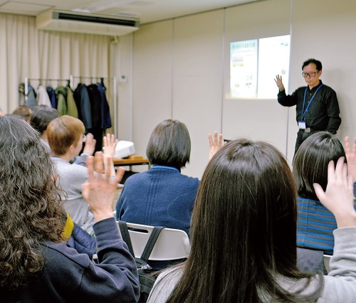 講師の動きに合わせて国際手話を実践する参加者