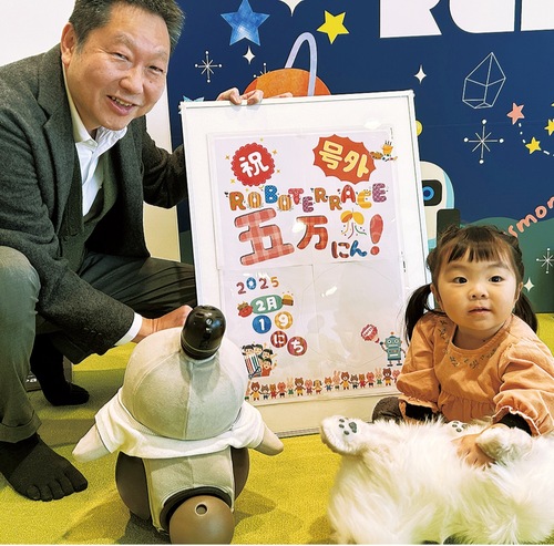 来場５万人目の朱々葉ちゃん（右）とお祝いに訪れた藤本専務理事