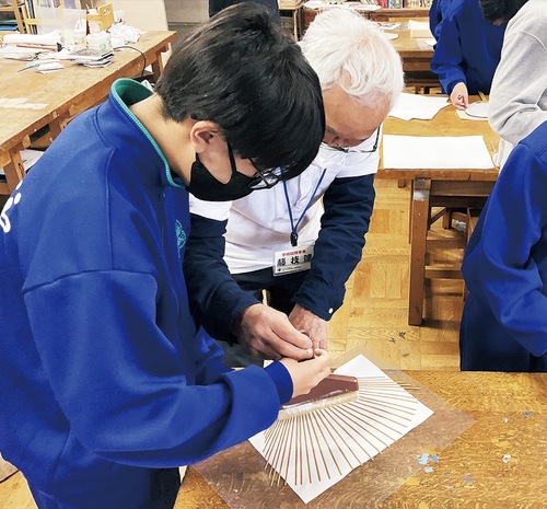 職人からうちわ作りを教わる生徒
