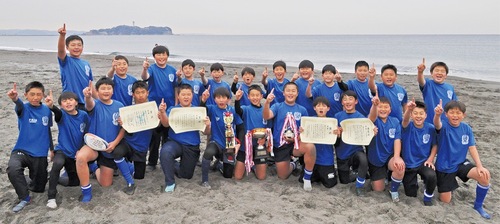 練習場の辻堂海岸で「一番」と人差し指を立てる６年生の選手