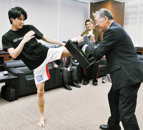永松選手（左）のキックをミットで体感する鈴木市長