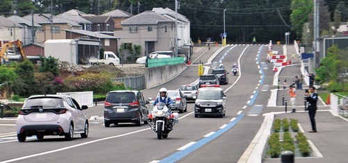 開通直後の道路を通行する警察車両