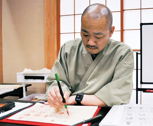 筆を執る小林住職