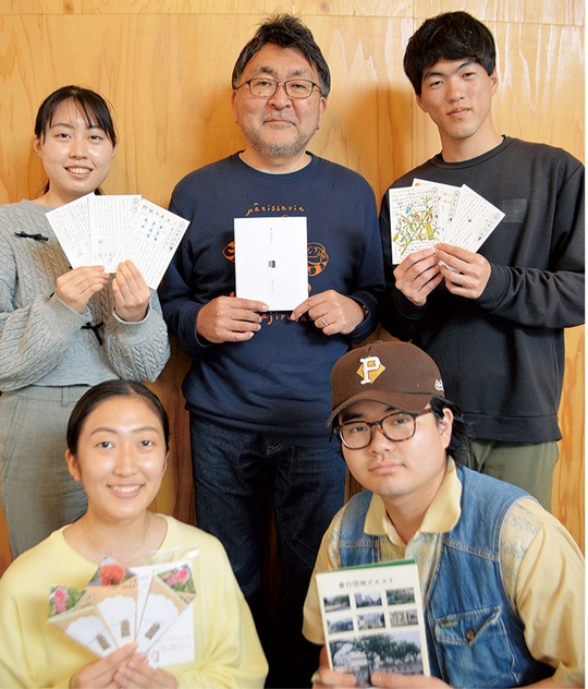 ＺＩＮＥを手にする学生と加藤教授（中央後ろ）