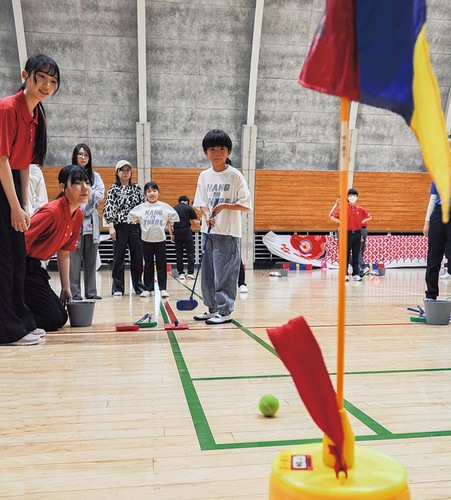 ゴルフ部員や家族らが見守る中、真剣な表情でパッティングする子ども