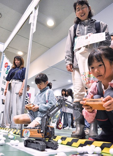 ショベルカーのおもちゃを操作する子どもたち