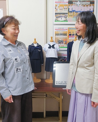 懐かしい制服の前で思い出を語らう門馬会長(左)と高橋さん