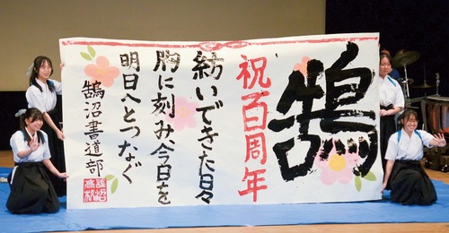 ステージ上で完成した書を披露する書道部員たち