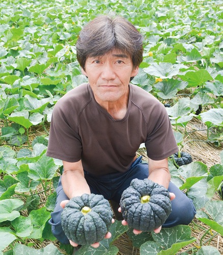 収穫したかぼちゃを持つ関根さん