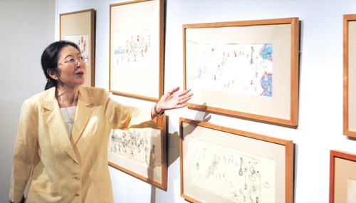 アートスペースで展示作品を解説する鈴木さん