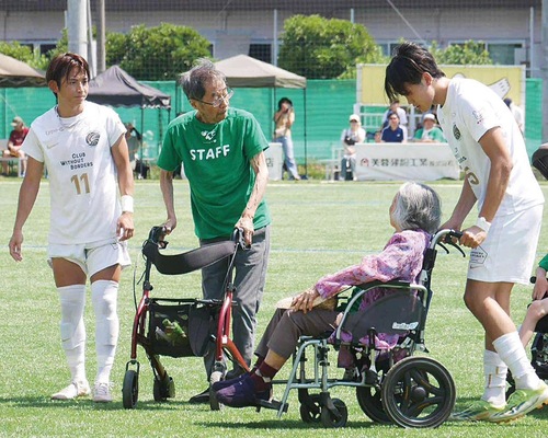 車いすで選手をエスコートする高齢者