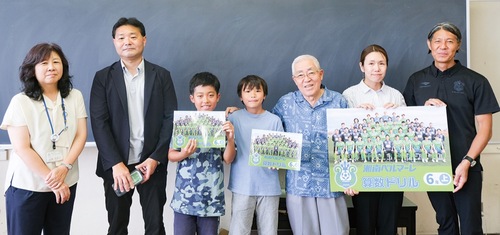 ドリルを受け取り笑顔の児童（中央）