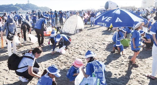 砂浜でごみを拾うブルーサンタたち