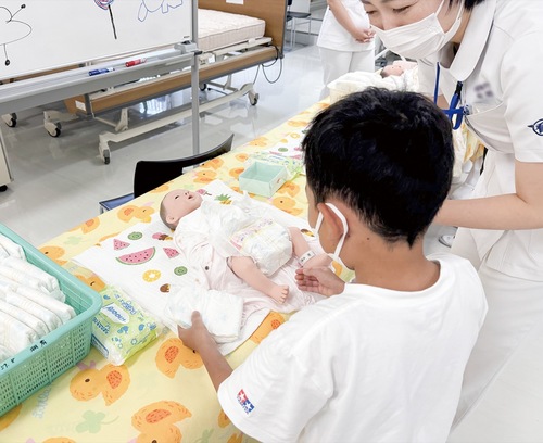 赤ちゃん人形のおむつ替えをする児童（大庭市民センター提供）