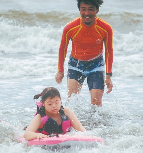 ボディーボードを使って波に乗る子ども