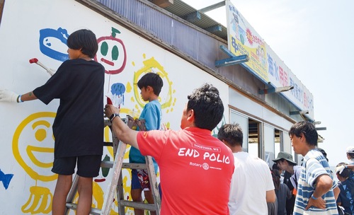 壁いっぱいに絵を描く子どもたち