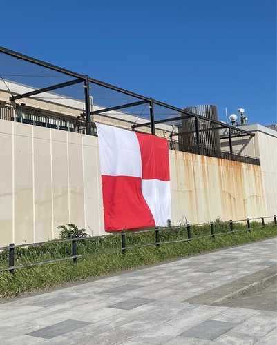 新江ノ島水族館の外壁に掲げられた津波フラッグ（同館提供）