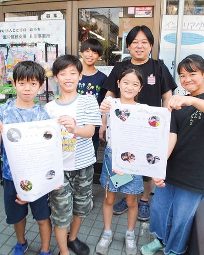 お礼状を手にする子どもたちと高見さん（右後ろ）