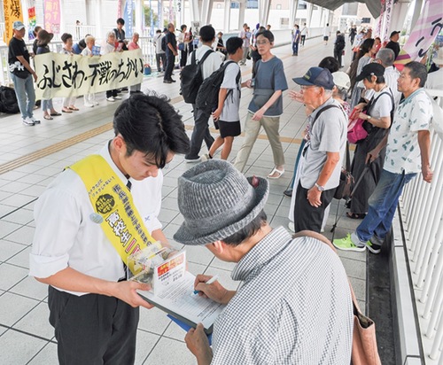行き交う人々に署名を求める高校生ら