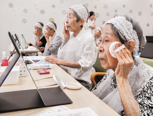 真剣な表情でファンデーションを顔に塗る参加者