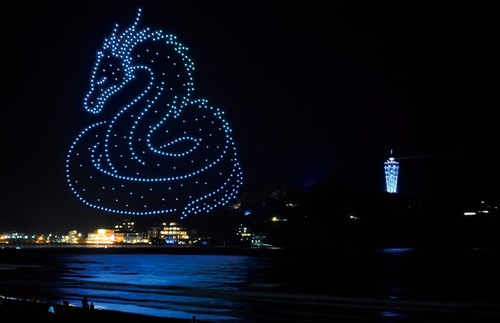 江の島をバックに夜空に浮かび上がるドローンによる龍神