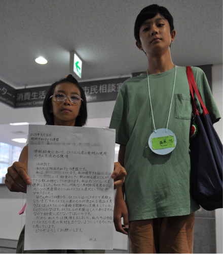 市民相談情報課の前で陳情書を手にする益永遥花さん（左）と悠さん