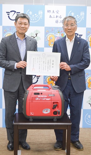 感謝状を受け取った依田代表(左)、LPガス発電機(中央)