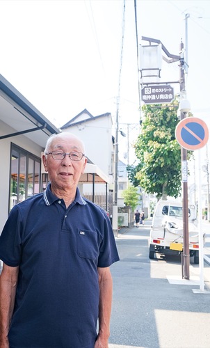 ｢匠のストリート｣と書かれた街灯前に立つ木下さん