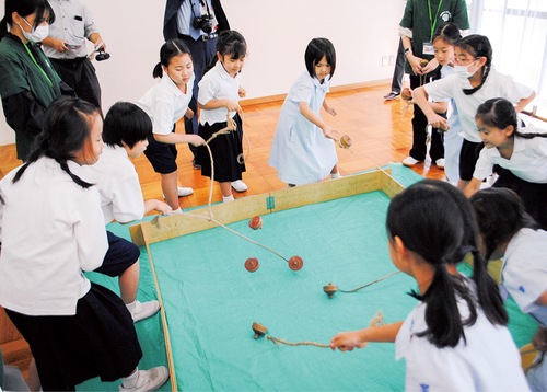 こま対決で白熱する児童ら