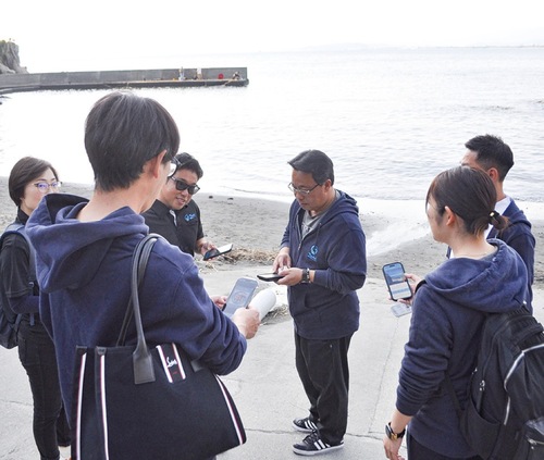 西浦漁港でスタンプラリーを行う参加者ら