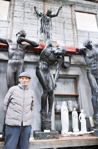 若き日に手掛けた作品の前に立つ親松さん