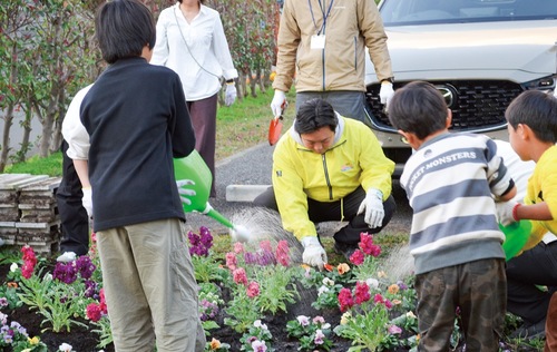 植えた花に水やりする子どもたち