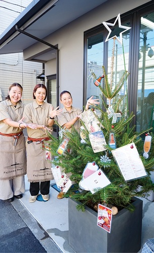 ビールやチキンの写真がぶら下がるクリスマスツリー