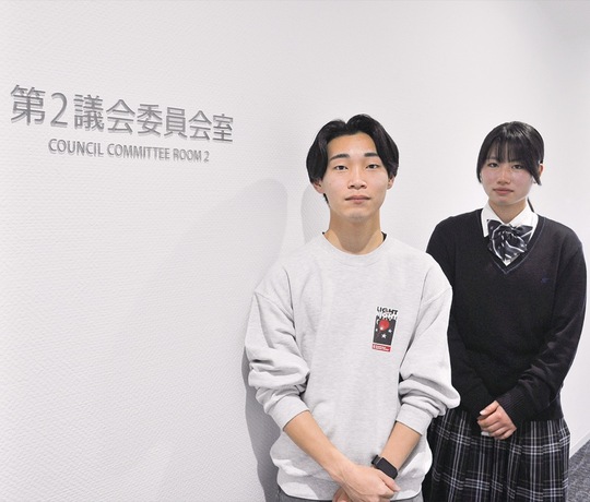 第２議会委員会室の前に立つ石原さん（左）と中島さん