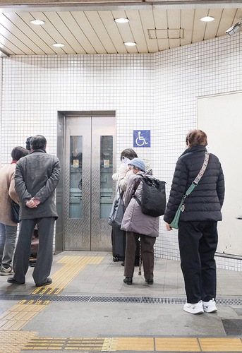 小田急線改札前のエレベーターを待つ人