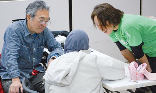 外国から来た女子生徒に数学を教えるボランティアスタッフ