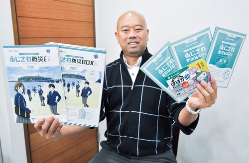 冊子などを手にする櫻井さん