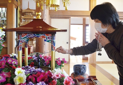 誕生仏に甘茶をかける参詣者