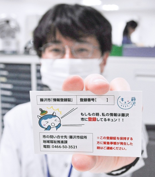 終活相談窓口で情報登録証を手にする職員
