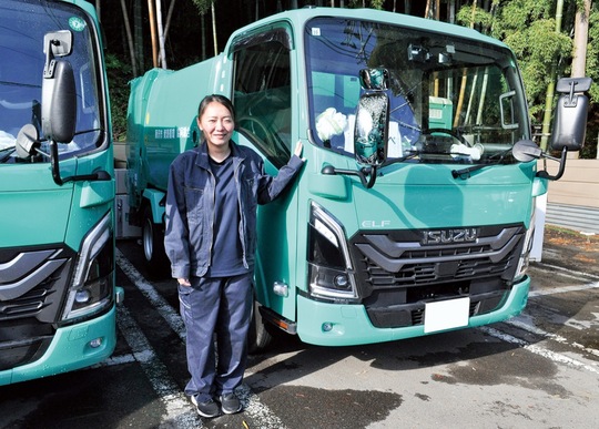 業務前にグリーンの車両の前に立つ遠藤さん