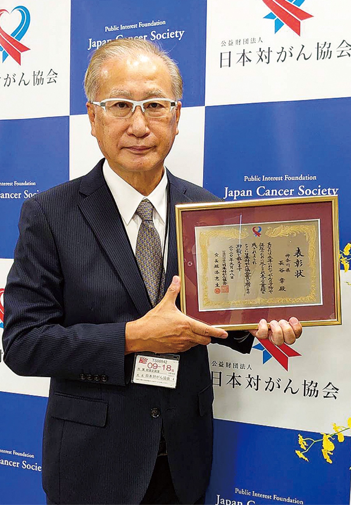 表彰状を持つ長谷さん