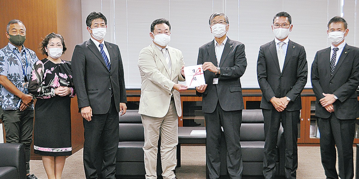 塩坂会長(中央)が鈴木市長(中央右)へ目録を渡した