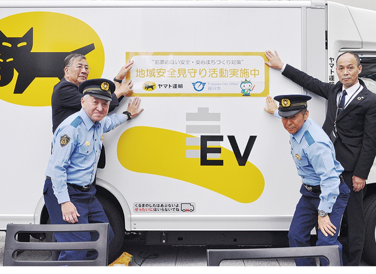 配送トラックにステッカーを貼る鈴木市長（左）ら