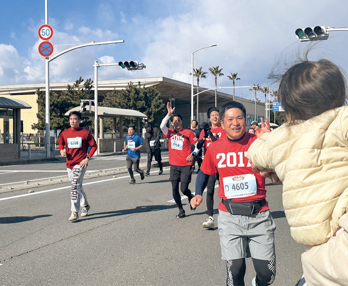 応援に訪れた娘とハイタッチするランナー