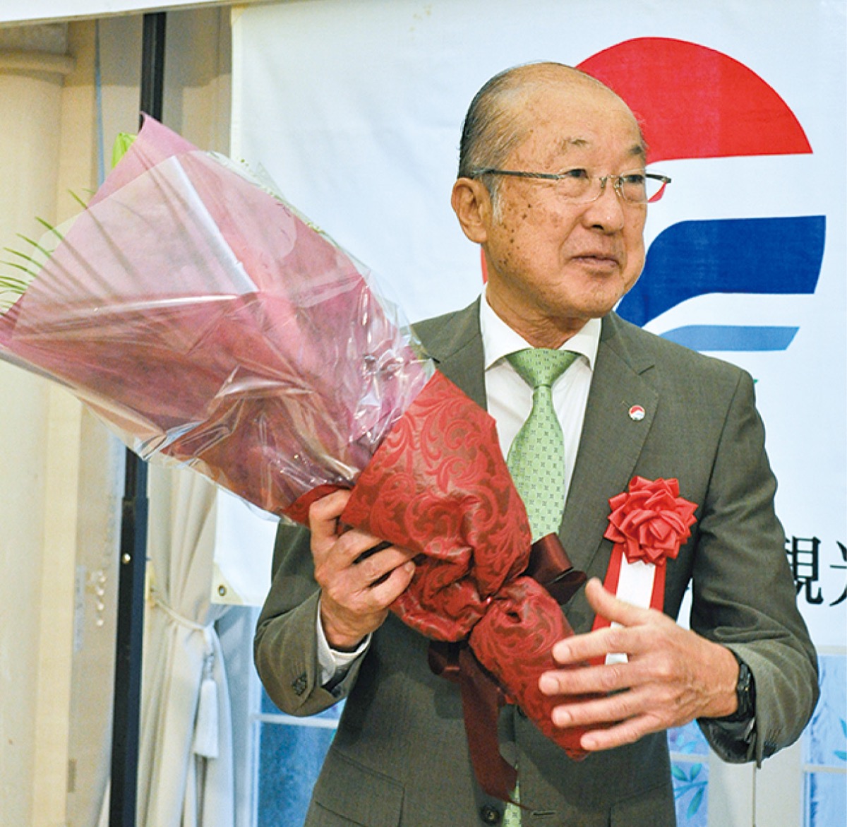 花束を受け取る湯浅前会長