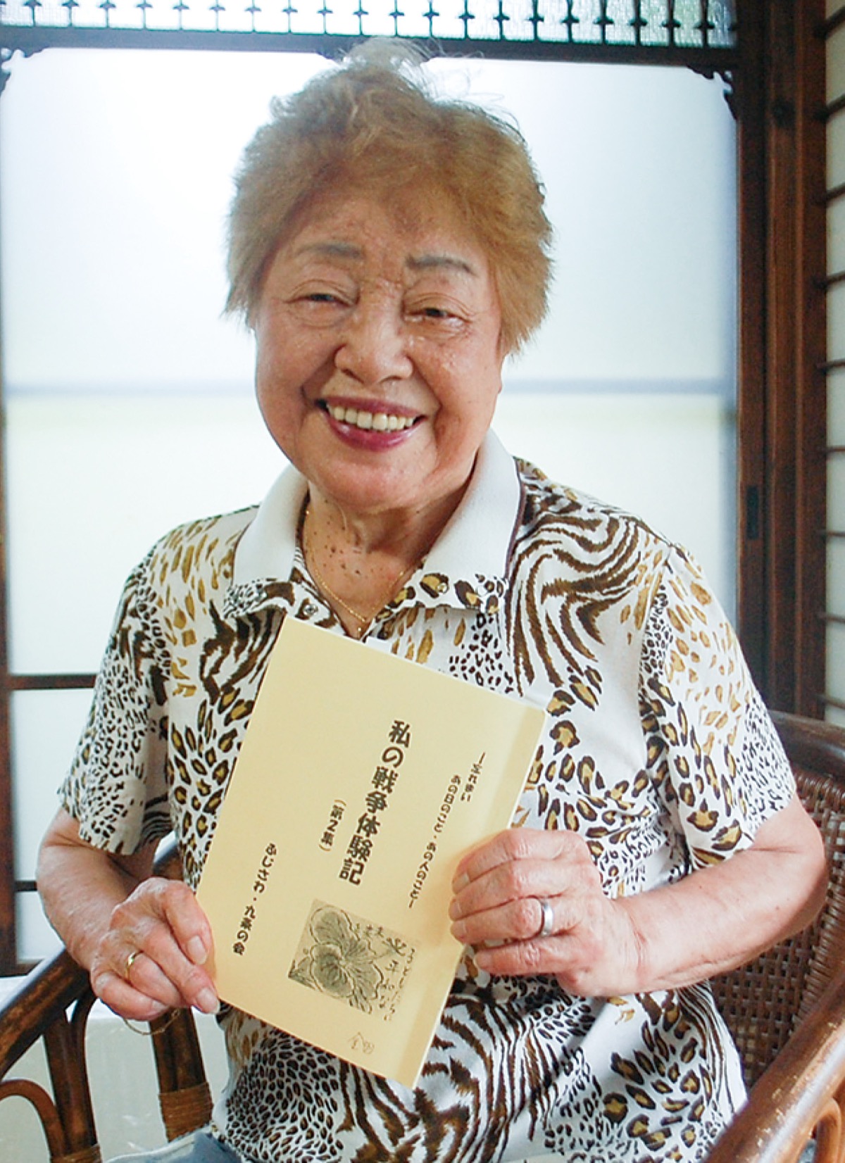 自身の戦争体験を記した本を手に持つ金田さん