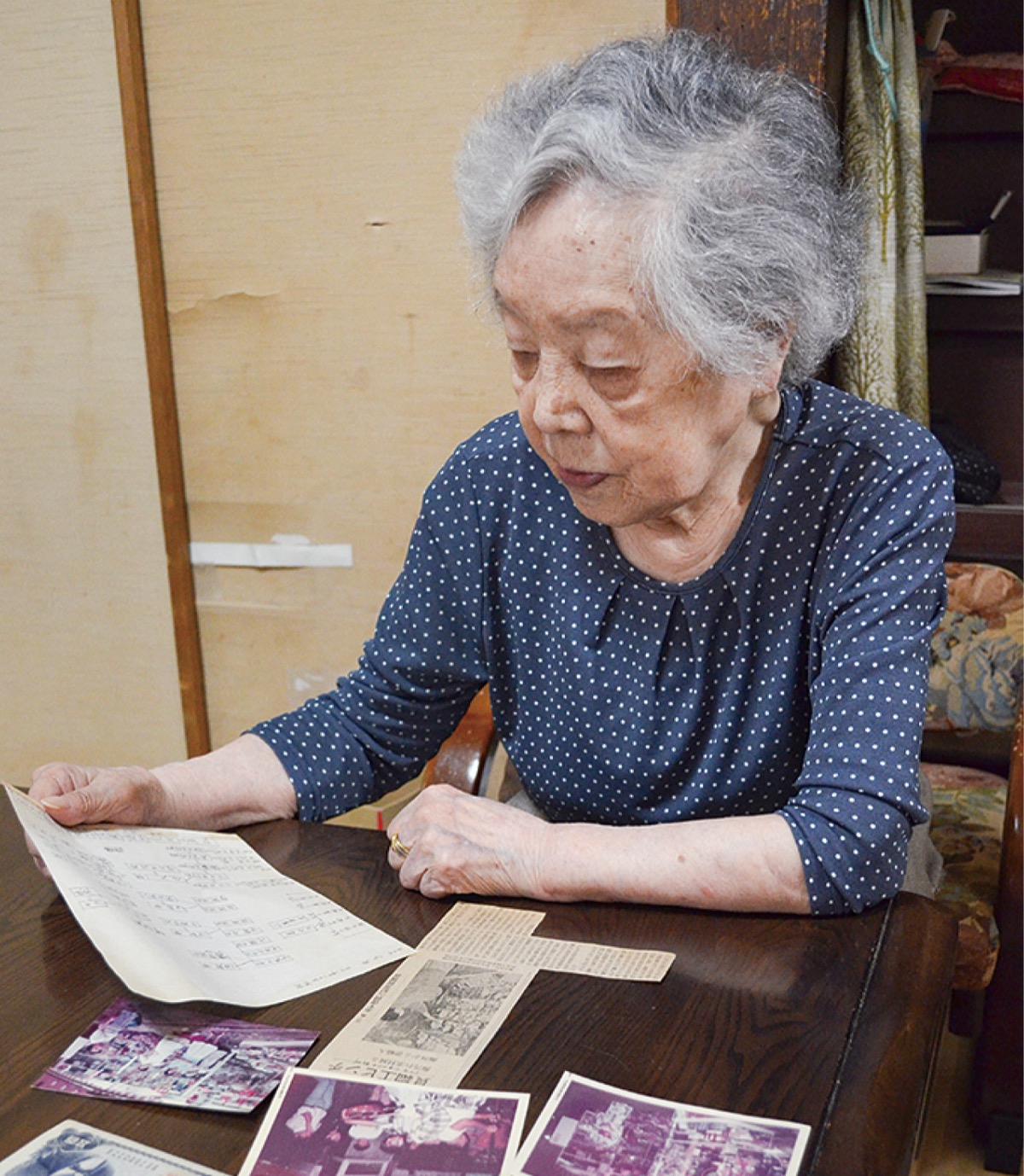 封筒に入れていた家系図を見つめる山本さん