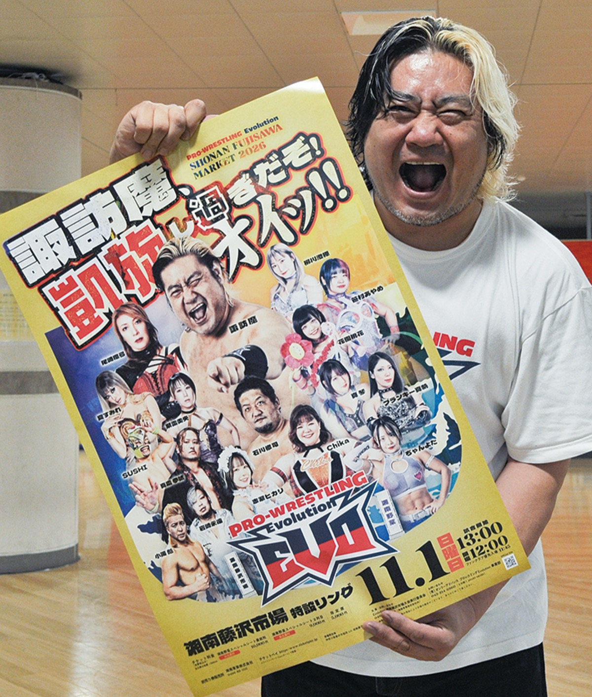 パワフルに大会ポスターを広げて見せる諏訪魔選手=5日、湘南台駅地下